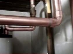 Checking rusty pipes during summertime plumbing maintenance